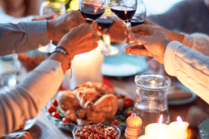 Friends celebrate Thanksgiving with a glass of wine and turkey together. This photo is for Thanksgiving ideas for bloggers' blog post