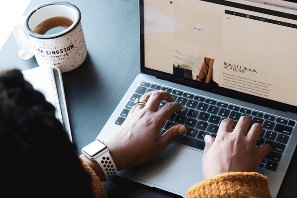 a woman writing on a laptop a blog post with the topic what is the difference between blogging and vlogging