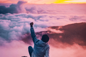 Cloudy sunset sky above the mountains and proud person, who has reached his dreams. Learn here 25 ways to improve your life