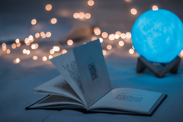 a photo showing an evening, a book, magical ball and lights in relation to angel number 1111
