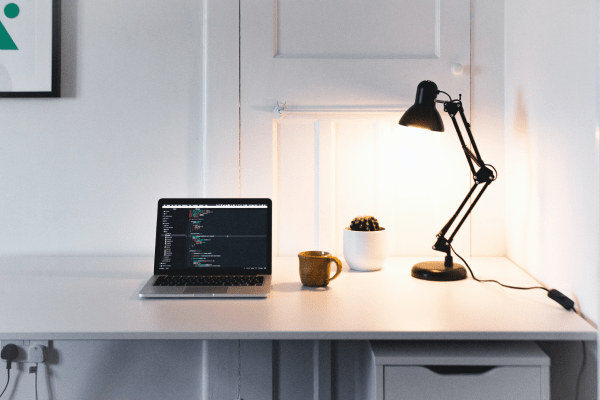 Image of a desk, lamp, computter for a blog post about best free wordpress plugins
