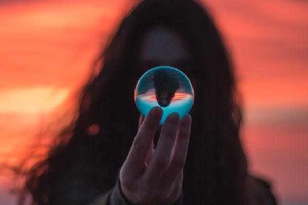 A girl holding a magical ball. Sunset background. The blog post is about morning affirmations for success