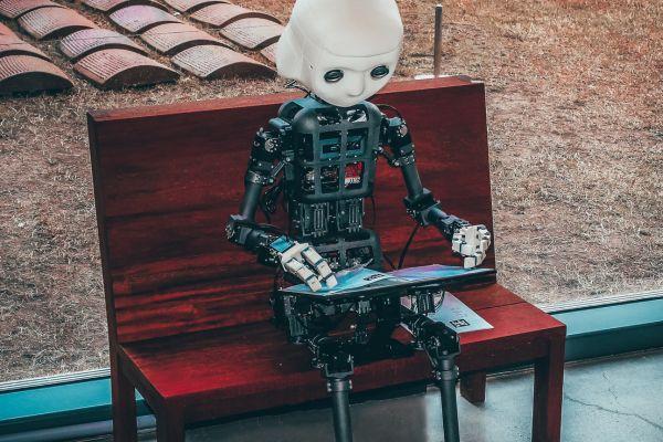 photo of a robot/ artificial intelligence that works on a computer regarding best ai affiliate programs blog post