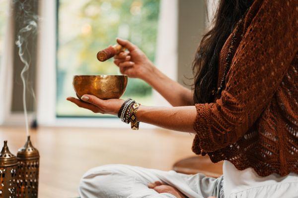 Woman holding a tibetian bowl and doing aromatherapie rituals in relation to a blog post about meditation gifts mindfulness