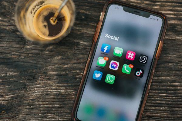 Phone with social media apps and coffee in relation to article about what do to instead of being on your phone and on social media. Discover what to do on mobile and not on mobile when bored